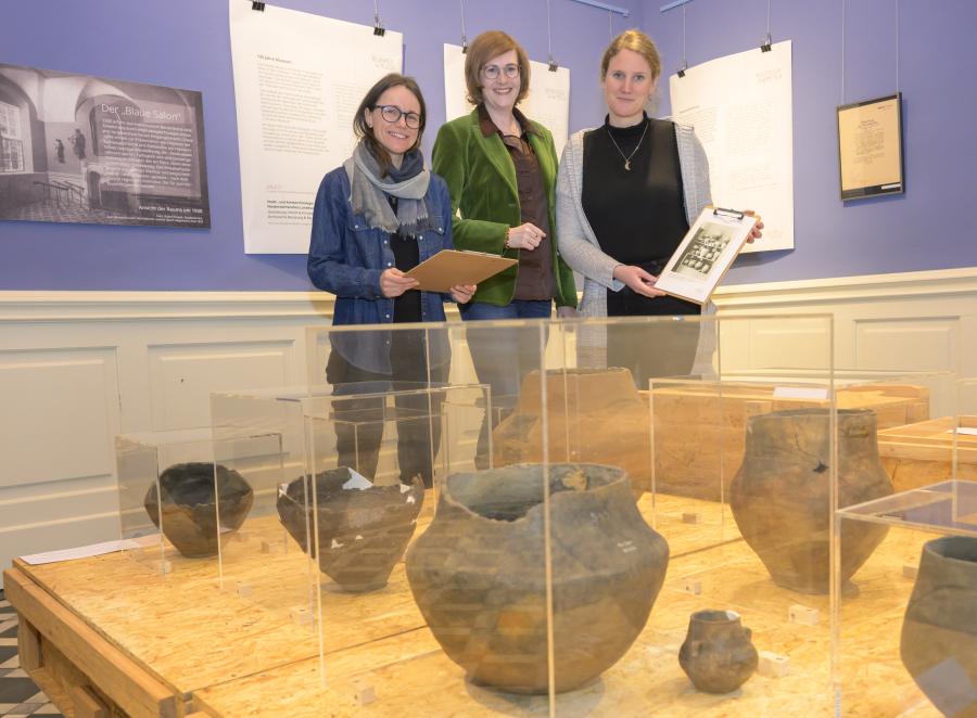 Judith Franzen (Stadt- und Kreisarchäologie Osnabrück), Anna Philine Schöpper (Niedersächsisches Landesarchiv, Abteilung Osnabrück) und Museumsleiterin Katharina Pfaff (von links) präsentieren zum 100. Museumsjubiläum eine Ausstellung über archäologische Fundstücke, die schon Museumsgründer Hermann Rothert im Kreismuseum in Szene gesetzt hatte. Foto: Landkreis Osnabrück/Hermann Pentermann