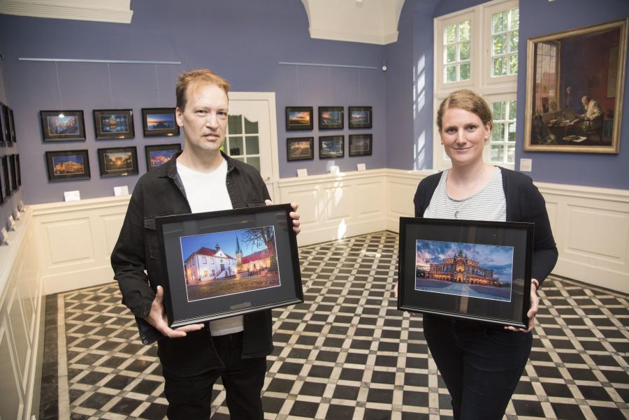 Eine Ausstellung zur Blauen Stunde im Blauen Salon: Fotograf Andreas Mally und Museumsmitarbeiterin Katharina Pfaff präsentieren Fotografien, die derzeit im Museum im Kloster in Bersenbrück zu sehen sind. Foto: Landkreis Osnabrück/Uwe Lewandowski