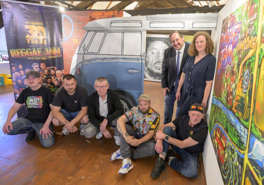 Bunt und kreativ präsentieren die Bunten Hunde das Thema 30 Jahre Reggae Jam im Museum im Kloster. Sitzend von links: Max „Optick“ Fuhrmann und Alexander „Miaskoh“ Cordes (beide Bunte Hunde), Bernard Wolinski (Museum im Kloster), Christian „Das Wort“ Aretz (Bunte Hunde) und Reggae-Jam-Gründer Bernd „Sheriff“ Lagemann; stehend: Kreistagsabgeordneter Jörg Brüwer und Museumsleiterin Katharina Pfaff. Es fehlt das Bunte-Hunde-Mitglied Marcel „Senf“ Ostendorf. Bild: Landkreis Osnabrück/Hermann Pentermann