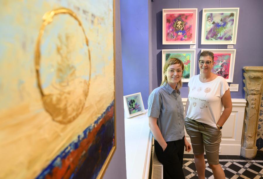 Zwischen Farben und Formen im Blauen Salon im Museum im Kloster: Museumsmitarbeiterin Claudia Stuckenberg (links) und Künstlerin Jutta Kirk-Lahrmann in der Ausstellung „Kunst von nebenan“.  Foto: Landkreis Osnabrück/Hermann Pentermann
