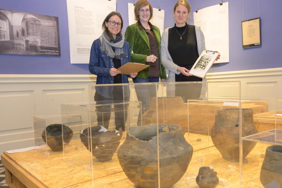 Judith Franzen (Stadt- und Kreisarchäologie Osnabrück), Anna Philine Schöpper (Niedersächsisches Landesarchiv, Abteilung Osnabrück) und Museumsleiterin Katharina Pfaff (von links) präsentieren zum 100. Museumsjubiläum eine Ausstellung über archäologische Fundstücke, die schon Museumsgründer Hermann Rothert im Kreismuseum in Szene gesetzt hatte. Foto: Landkreis Osnabrück/Hermann Pentermann