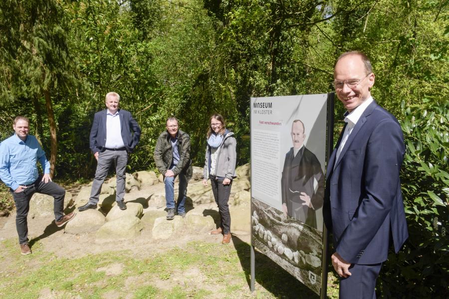 Landrat Michael Lübbersmann (rechts) weiht die Informationstafel am Steinblockkranz ein. Fabian Schröder und Burkhard Fromme (Kulturbüro des Landkreises Osnabrück) sowie Axel Friederichs und Judith Franzen (Stadt- und Kreisarchäologie) entdecken bereits die freigelegten Steine (v.l.n.r.)