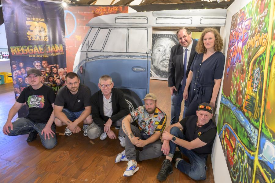 Bunt und kreativ präsentieren die Bunten Hunde das Thema 30 Jahre Reggae Jam im Museum im Kloster. Sitzend von links: Max „Optick“ Fuhrmann und Alexander „Miaskoh“ Cordes (beide Bunte Hunde), Bernard Wolinski (Museum im Kloster), Christian „Das Wort“ Aretz (Bunte Hunde) und Reggae-Jam-Gründer Bernd „Sheriff“ Lagemann; stehend: Kreistagsabgeordneter Jörg Brüwer und Museumsleiterin Katharina Pfaff. Es fehlt das Bunte-Hunde-Mitglied Marcel „Senf“ Ostendorf. Bild: Landkreis Osnabrück/Hermann Pentermann