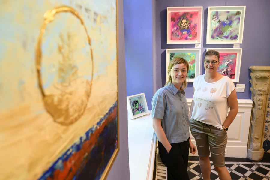 Zwischen Farben und Formen im Blauen Salon im Museum im Kloster: Museumsmitarbeiterin Claudia Stuckenberg (links) und Künstlerin Jutta Kirk-Lahrmann in der Ausstellung „Kunst von nebenan“. Foto: Landkreis Osnabrück/Hermann Pentermann